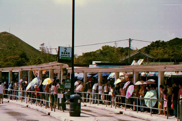 Waiting for the bus in the searing heat - not without an umbrella